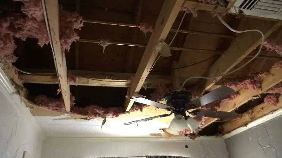 Water-stained ceiling torn open from a leak above in an Orem home